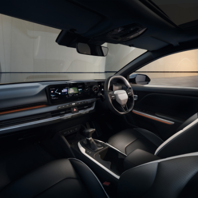 Interior of a modern car showing steering wheel and dashboard with digital displays.