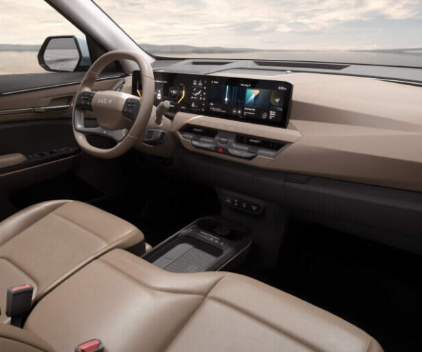 Interior view of a car with tan leather seats and a digital dashboard display.