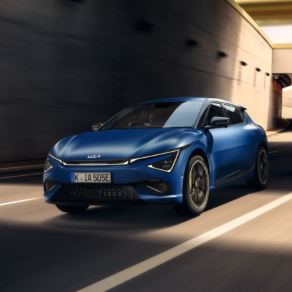 Blue modern car driving on a road, viewed from the front side.