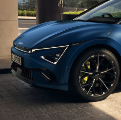 Close-up of a blue car's front angle showing wheel and part of headlight design.