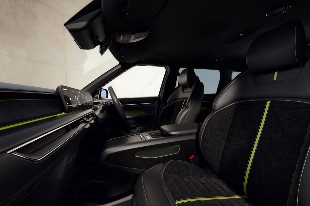 Car interior with black and green seats, modern dashboard, and steering wheel.