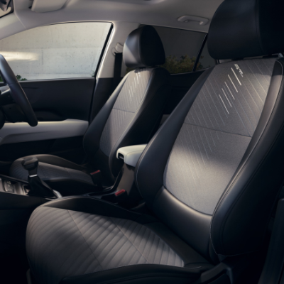 Front seats of a car with black and grey upholstery and a centre armrest.
