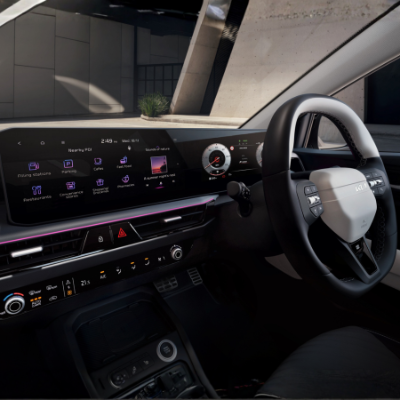 Interior view of a car dashboard with digital displays and a steering wheel.