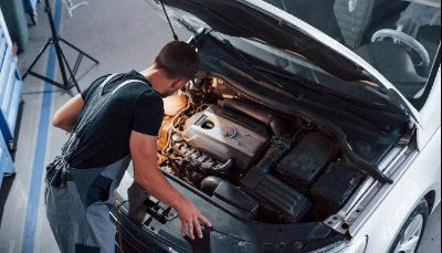 Man looking in a cars bonnet