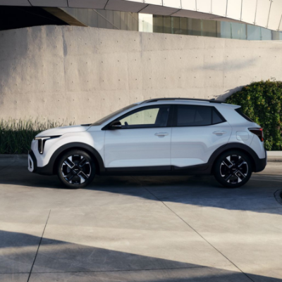 White SUV parked on a concrete surface with greenery on the side.