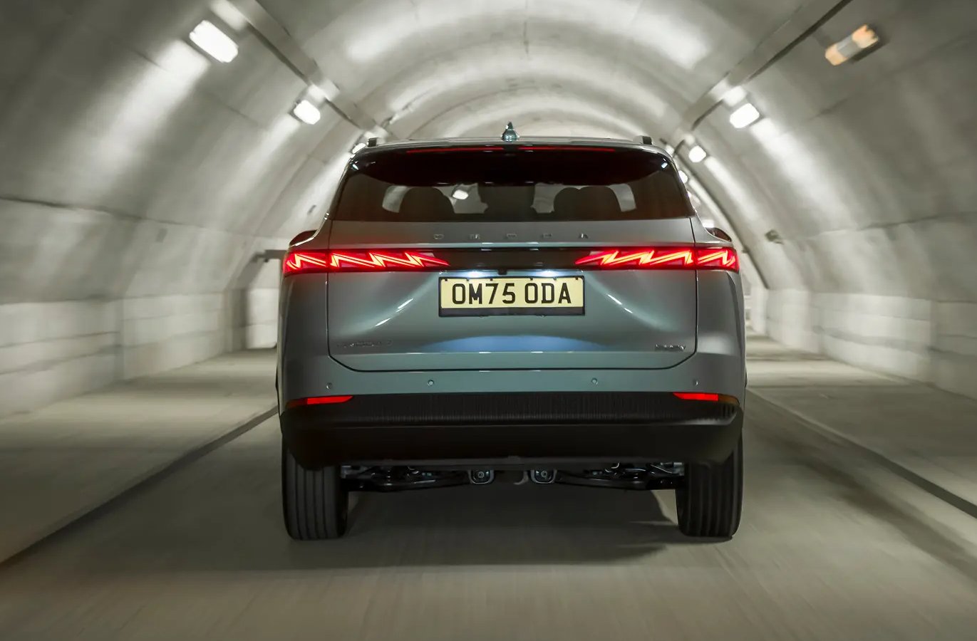 Rear view of a car with OM75 ODA licence plate driving through a tunnel.